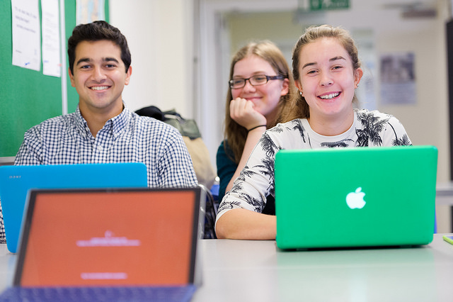 Smiling students in class at their computers