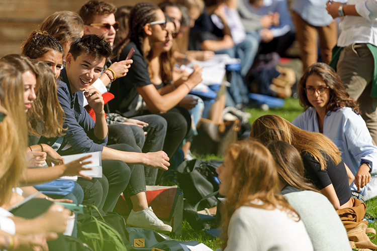 Students sitting on the lawn of the London campus